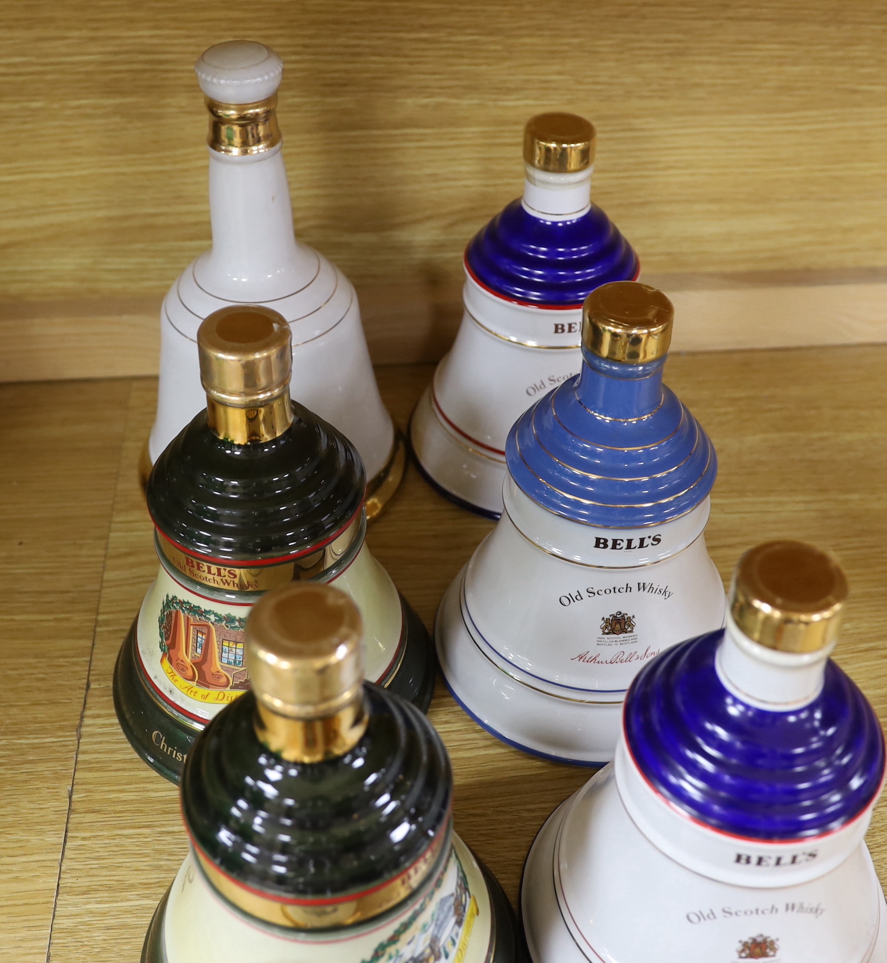 Eleven Wade pottery Bells whisky decanters with contents, one with box